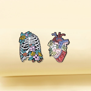 Detailed set of enamel rib cage and heart brooches with colorful floral patterns