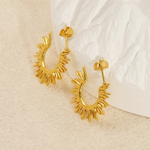 Elegant gold titanium steel sunburst hoop earrings on a textured minimalist background