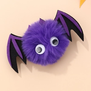 Detail of purple plush Halloween bat hair clip with fuzzy wings and googly eyes