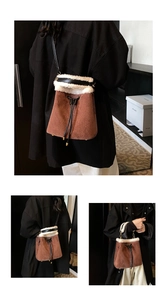 Close-up of brown suede bucket bag featuring white faux fur trim and gold metal hardware