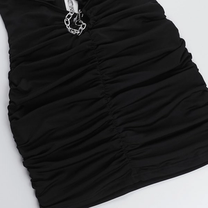 Detail view of black bodycon dress featuring metallic silver chain and ruched knit texture