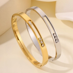 Titanium steel bangle featuring a sliding three-diamond groove in gold and silver finish