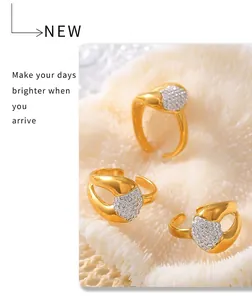 Close-up of three gold heart-shaped rings with diamonds on a textured background