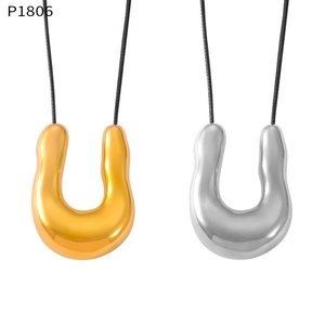 Macro detail of U-shaped gold and silver pendants with polished finish on black cord