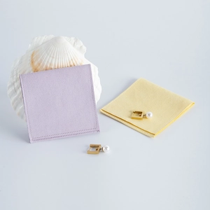 Detail of lavender and pale yellow suede jewelry pouches with elegant pearl earrings