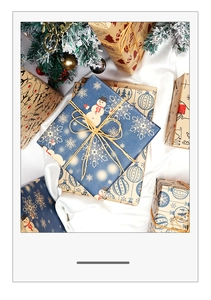 Detail of Christmas kraft wrapping paper featuring reindeer and snowflakes with hemp rope ties