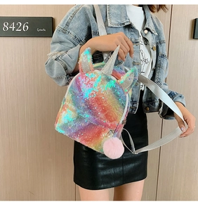 Close-up of unicorn backpack with rainbow sequins and pink fur ball pompom detail