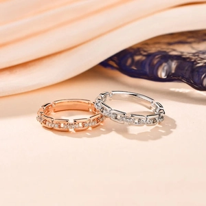 Detail von Kettengliedringen in Roségold und Silber mit funkelnder Zirkonia-Verzierung