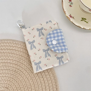 Detailed view of floral pattern fabric wallet with blue bow print and snap button closure
