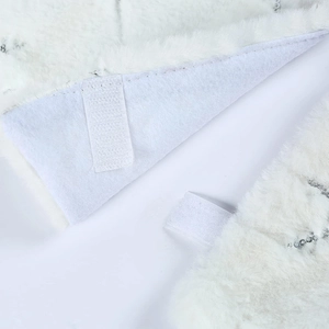 Close-up of white faux fur Christmas tree skirt with silver sequins and velcro straps