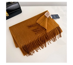 Detail of 100% Australian wool scarf in caramel color with fringe texture and tag