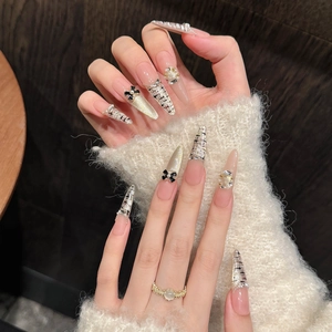 Handmade stiletto press-on nails with tweed patterns, black bows, pearls, and glitter