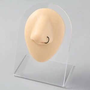 Detail view of a black stainless steel U-shaped nose ring with clear stone on a nose model