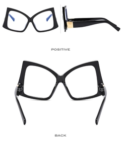 Detail view of butterfly frame glasses showing golden metal hinges and blue light coating