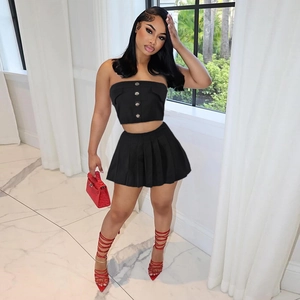 Detail of black two-piece set featuring buttoned tube top and pleated mini skirt