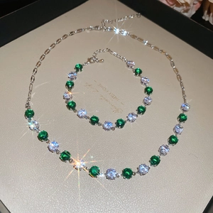 Macro shot of sparkling emerald green and white zircon necklace and bracelet set