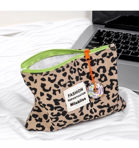 Dettaglio della borsa leopardata con zip verde e ciondolo floreale di perline arancioni