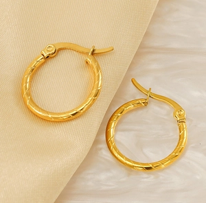 Detail showing the spiral twisted texture and lever back clasp of 18K gold hoop earrings