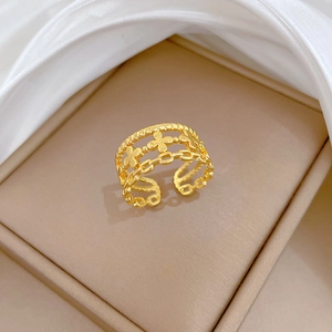 Bague trèfle dorée ajustable avec design de chaîne tressée dans un écrin à bijoux