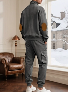 Détail du haut en tricot gris foncé avec texture à carreaux et coudières marron