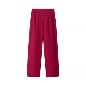 Dettaglio dei pantaloni da completo color magenta a vita alta con eleganti pieghe