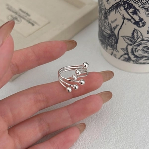 Detailed view of layered S925 sterling silver ring with polished beads on fingers