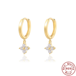 Macro shot of 925 sterling silver four-leaf clover earrings with sparkling white zircons