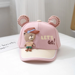 Detail of baby baseball cap with 3D cartoon bear ears and Let's Go text on pink fabric