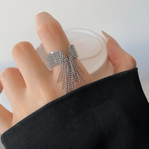 Detail of silver bead chain tassel open ring on hand showing modern minimalist design