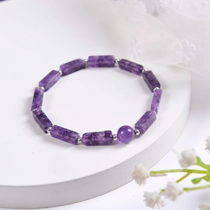 Natural amethyst and rectangular stone bead bracelet on an elegant white display stand