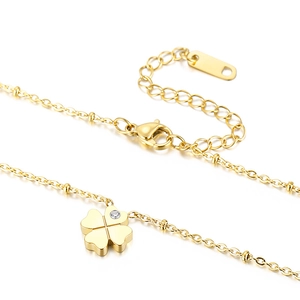 Golden clover pendant necklace in stainless steel with crystal detail on a white backdrop