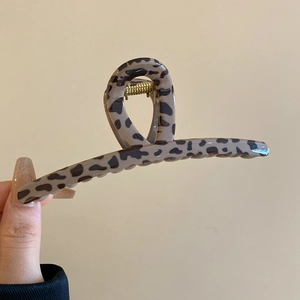Detail view of large leopard print hair claw clip with a glossy finish and metal spring
