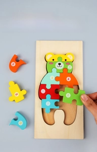 Close-up of child's hand assembling a wooden bear puzzle with numbered pieces 1-10