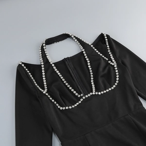 Detail of rhinestone chain cutout on the neckline of a sexy black evening dress