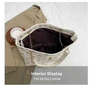 Spacious interior of a vintage monogram tote bag with chain strap and soft beige lining