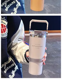 Detail of insulated coffee mug with foldable handle and transparent lid with metal rim
