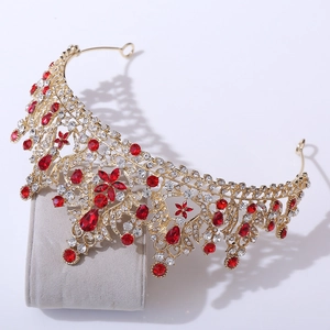 Detailed close-up of golden bridal tiara with red crystals and floral patterns