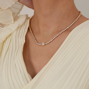 Detailansicht einer goldenen Tennishalskette mit Strass und rechteckigem Muscheleinleger