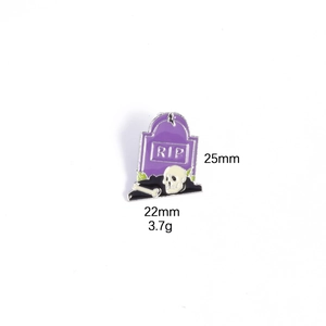 Detail view of purple RIP tombstone enamel pin with skull and bones for Halloween