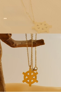 Detail of 18K gold plated nautical helm pendant necklace with delicate O-chain link texture