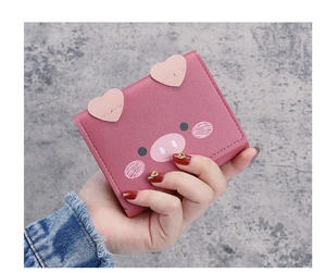 Close-up of pink cartoon pig wallet showing cute leather ears and texture in hand