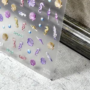 Detalle macro de pegatinas de uñas 3D con relieve de mar, con conchas y caballitos de mar