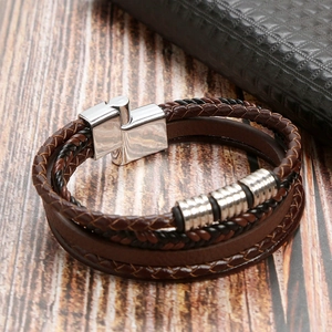 Detail of multi-layer leather bracelet featuring braided ropes and silver metallic clasp