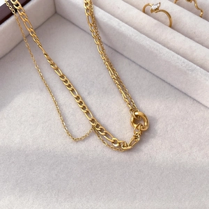 Close-up of gold double-layer necklace with Figaro chain in a jewelry display box