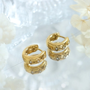 Boucles d'oreilles dorées avec breloques étoile et œil serties de zircones