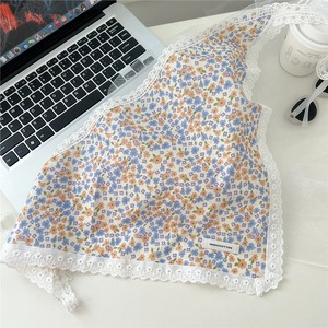 Close-up of floral cotton triangle scarf with white lace trim and 100% cotton label