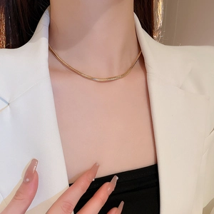 Nahaufnahme einer minimalistischen goldenen Schlangenkette an einem Modemodell
