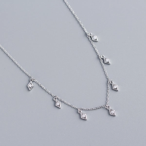 Detail of silver S925 necklace with geometric rhombus tassels and sparkling zircon stones