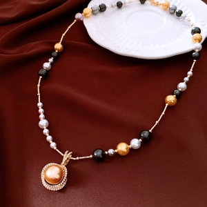 Détail d'un collier de perles multicolores avec pendentif doré serti de cristaux brillants