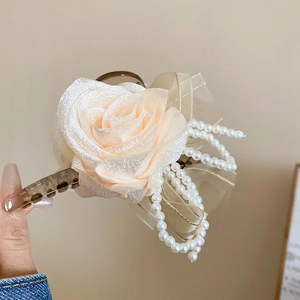 Dettaglio molletta per capelli con fiori di pizzo, nappa di perle e fiocco